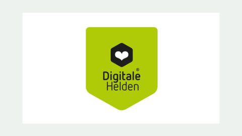 In einem grünen Kasten sind die Worte Digitale Helden in schwarzer Schrift zu sehen. Darüber ist ein weißes Herz in einer schwarzen Raute zu sehen.