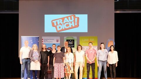 Auf der Bühne die Organisatorinnen und Organisatoren mit den vor Ort befindlichen Ansprechpersonen der Beratungsstellen