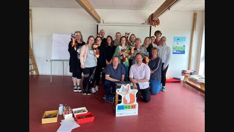 Gruppenbild der Teilnehmerinnen und Teilnehmer des Basisworkshop bei der Übergabe des MEKOKI Pappaufsteller