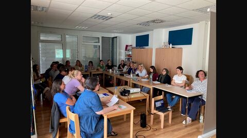 Teilnehmerinnen des Basisworkshop sitzen an Tischen