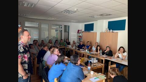 Teilnehmerinnen und Referent folgen einer Präsentation aus einem Praxisteil. 