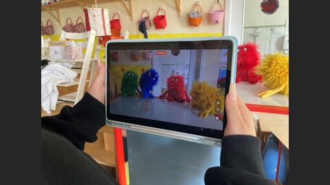 Auf dem Display eines Tablets ist eine Szene aus dem Rollenspiel mit den Monstern zu sehen.